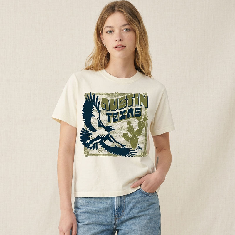 Woman wearing Hawk & Thorn boxy t-shirt with flying hawk and cactus graphic