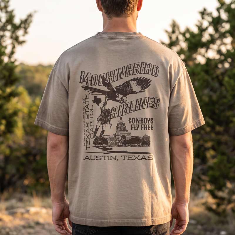 Back view of model wearing Mockingbird Express Austin Texas oversized heavyweight T-shirt with large vintage screen print