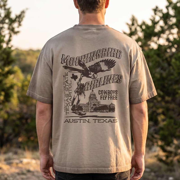 Back view of model wearing Mockingbird Express Austin Texas oversized heavyweight T-shirt with large vintage screen print