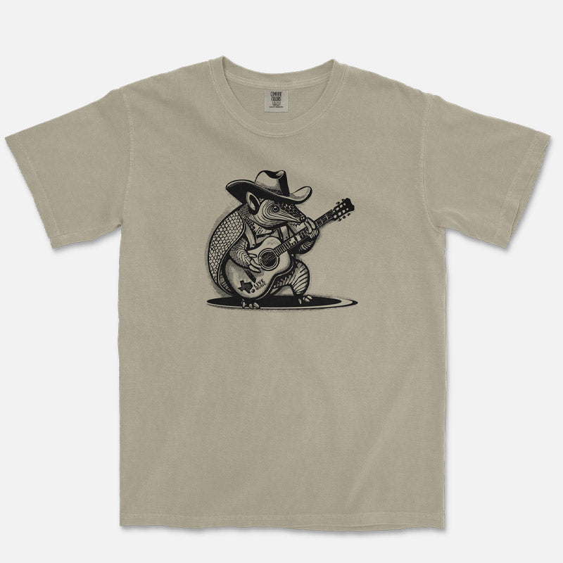Rockin Armadillo unisex t-shirt on sandstone Comfort Colors 1717 featuring a guitar-playing armadillo graphic in black ink