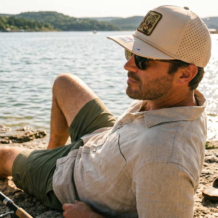 Person wearing the Lost Draw Provisions Lost Hawk khaki rope hat outdoors in a Texas-inspired setting, showcasing the detailed hawk patch and rugged outdoor style.