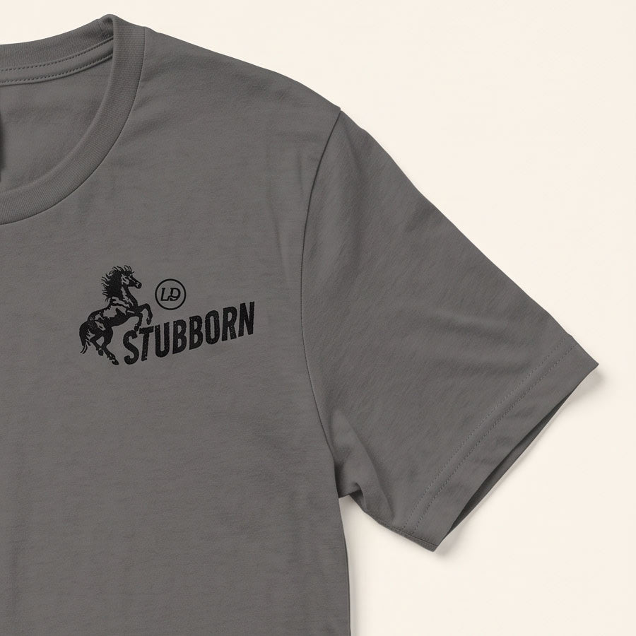A close-up of a dark gray crewneck t-shirt featuring a black graphic print on the left chest with a rearing horse, a circular &